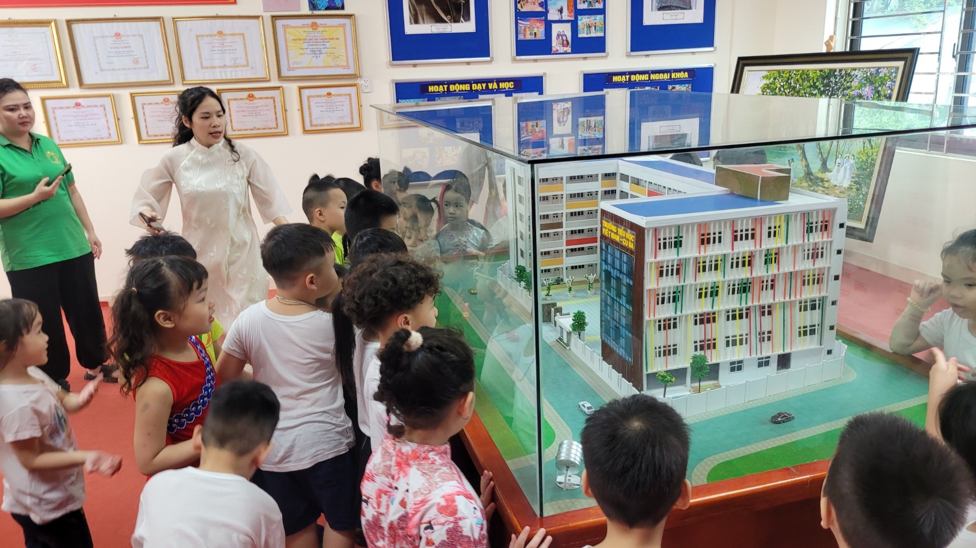 A group of children looking at a model of a building

Description automatically generated